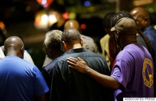 Worshippers gather to pray in a hotel parking lot across the street from the Emanuel AME Church following a shooting Wednesday, June 17, 2015, in Charleston, S.C. (AP Photo/David Goldman)